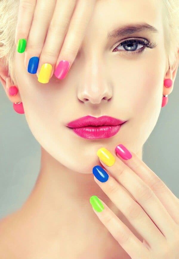 Manicura multicolor brillante con labios rosa